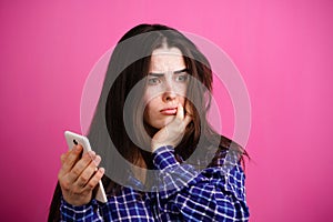 Sad depressed woman looking at mobile phone.