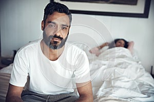 Sad, depression and portrait of a man on a bed with wife sleeping in the morning. Upset, depressed and a mature male