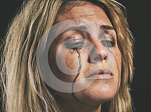 Sad, depression and woman crying with makeup smudge on face from tears with studio wall closeup. Depressed, hopeless and