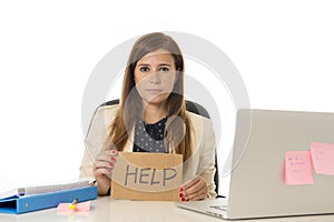 Sad desperate businesswoman in stress at office computer desk holding help sign