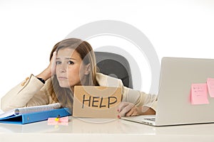 Sad desperate businesswoman in stress at office computer desk holding help sign