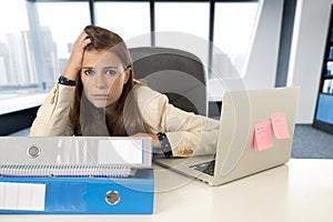 Sad and desperate businesswoman suffering stress and headache at office laptop computer desk
