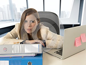 Sad and desperate businesswoman suffering stress and headache at office laptop computer desk