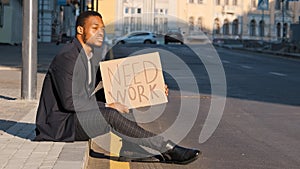 Sad desperate frustrated ethnic employee office worker African American man male guy sitting on steps outdoors holding