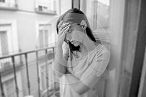 Sad desperate hispanic girl at home balcony looking depressed suffering terrible migraine headache disorder or depression