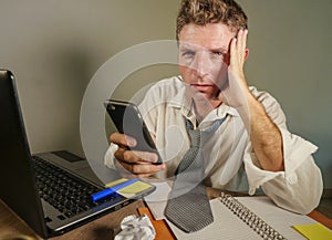 Sad desperate man in lose necktie messy and depressed working at laptop computer in business office problem and stress concept ho