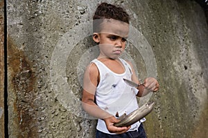 Sad destitute african american boy holding photo