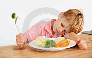 Sad, diet and a child with vegetables for dinner, unhappy meal and problem with food. Frustrated, hungry and dislike of