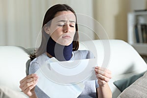 Sad disabled woman reading bad news on letter