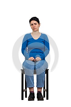 Sad and disappointed woman sitting on a chair looking indisposed to camera, full length isolated over white background. Upset