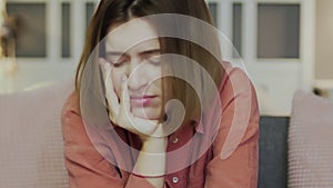 Sad and disappointed woman sitting on the sofa and watching TV