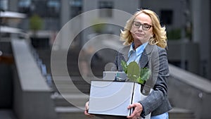 Sad dismissed business woman holding stuff box, unprofessional worker, failure