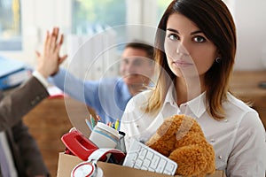 Sad dismissed woman against background of joyful colleagues partners in office