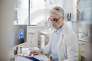 Sad doctor looks at an MRI scan, patient's bad test results, feeling helpless. Recurrence of the disease