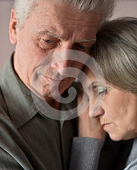 Sad elder couple on brown background