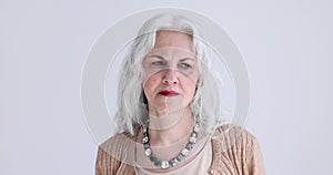 Sad elderly gray-haired woman is bored on white background portrait 4k movie