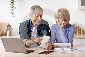 Sad elderly husband and wife checking their expenses