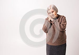 Sad elderly woman lay down on folded arms