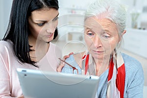 Sad elderly woman after receiving email in tablet