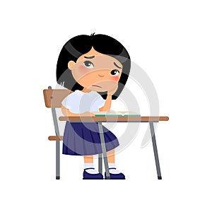 Sad elementary school student flat color vector illustration. Unhappy asian schoolgirl sitting at table and reading book.