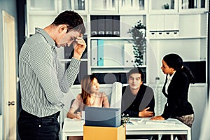 Sad employee packing his belongings after being fired for not being competent.