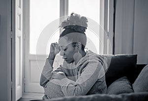 Sad and exhausted young african american woman suffering from depression alone at home