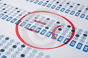 Sad face drawn on answer sheet, closeup. Student passing exam