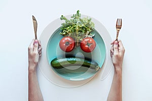 Sad face of vegetables in plate. The concept of dietary restrictions, healthy lifestyle, diet, weight loss, anti-obesity, healthy