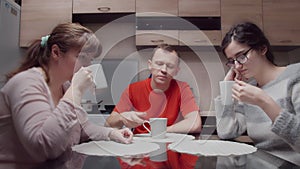 Sad family silently drinking hot tea in the kitchen in the evening