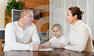 Sad family of three with documents photo