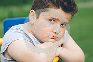 Sad fat boy sitting on the sports simulator