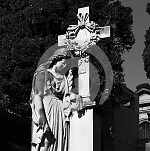 Sad female figure standing by the cross photo