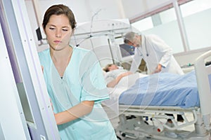 Sad female nurse at hospital corridor