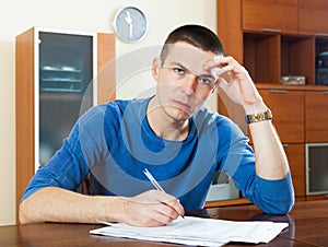 Sad frustrated guy filling out paperwork