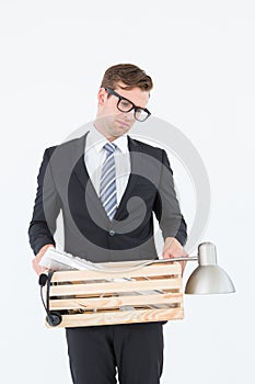 Sad geeky businessman holding box of his things