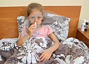 A sad girl buries herself with drops in her nose while lying in bed. Self-treatment