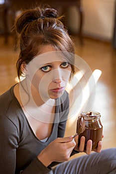 Sad girl is eating chocolate spread