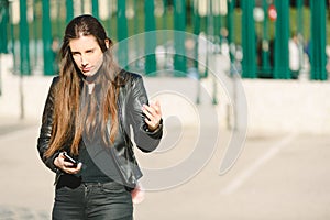 Sad girl feeling upset receiving bad news in mobile message on smartphone at street, depressed and sad young woman holds phone
