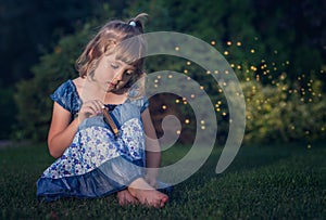 Sad girl with harmonica sitting on grass