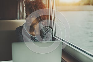 Sad girl with laptop in ship cabin