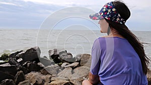 Sad girl looking afar at the seaside