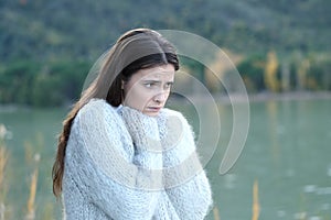 Sad girl looking away in a lake in winter photo