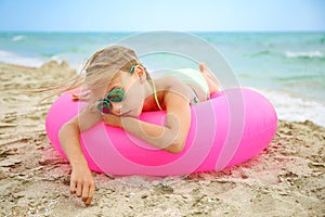 Sad girl lying on pink inflatable circle