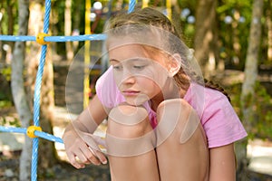 Sad girl at the playground. the sad child became thoughtful. loneliness
