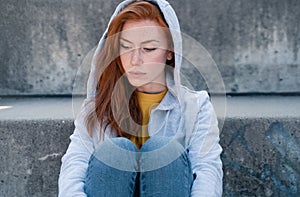 Sad girl portrait wearing hooded sweatshirt outdoor