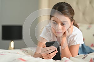 Sad girl reading a bullying post on social media