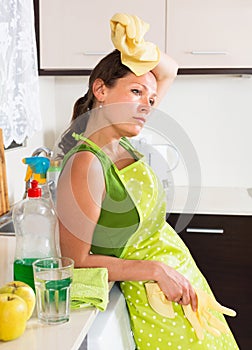 Sad girl washing interior in kitchen