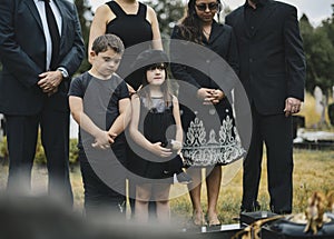 Sad grandkids standing by the grave