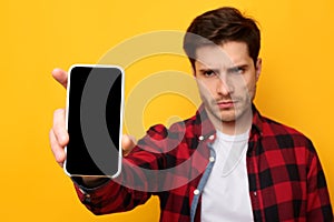 Sad guy holding showing empty smartphone screen