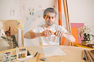 Sad guy Illustrator artist breaks a pencil in the throes of creativity. State of apathy, frustration and creative crisis